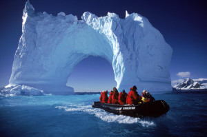 Boating By An Iceberg Arch Near Yalour Islands, Antarctica.